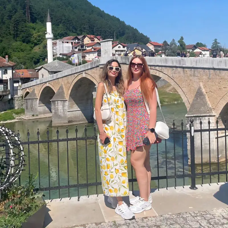 İki misafir Konjic'te Neretva üzerindeki taş köprünün önünde